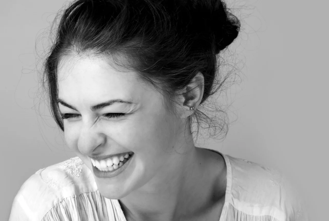 Woman laughing in black and white, Centre dentaire Ô Dentiste visual