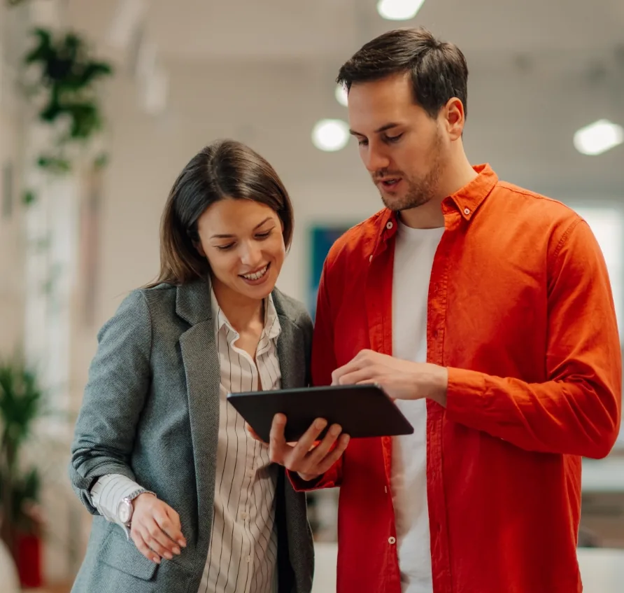Two colleagues looking at a tablet in an office